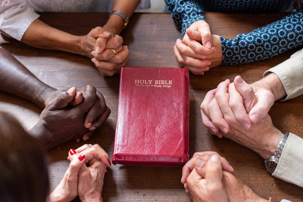 Handen rond de Holy Bible Handen rond de Holy Bible